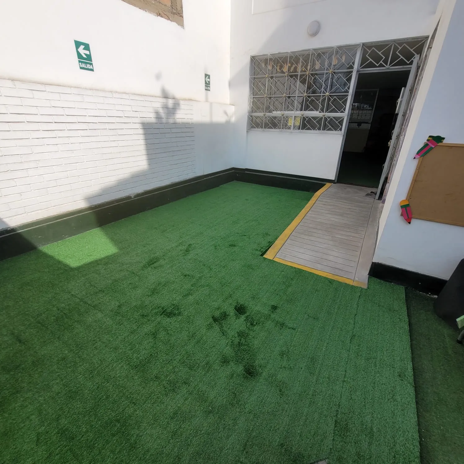 Zona de recreo exterior con césped artificial — guardería Brisa de Hogar Los Olivos Lima