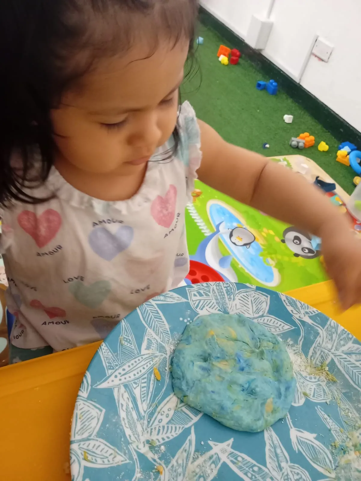 Niña explorando masa sensorial — estimulación temprana en guardería Brisa de Hogar