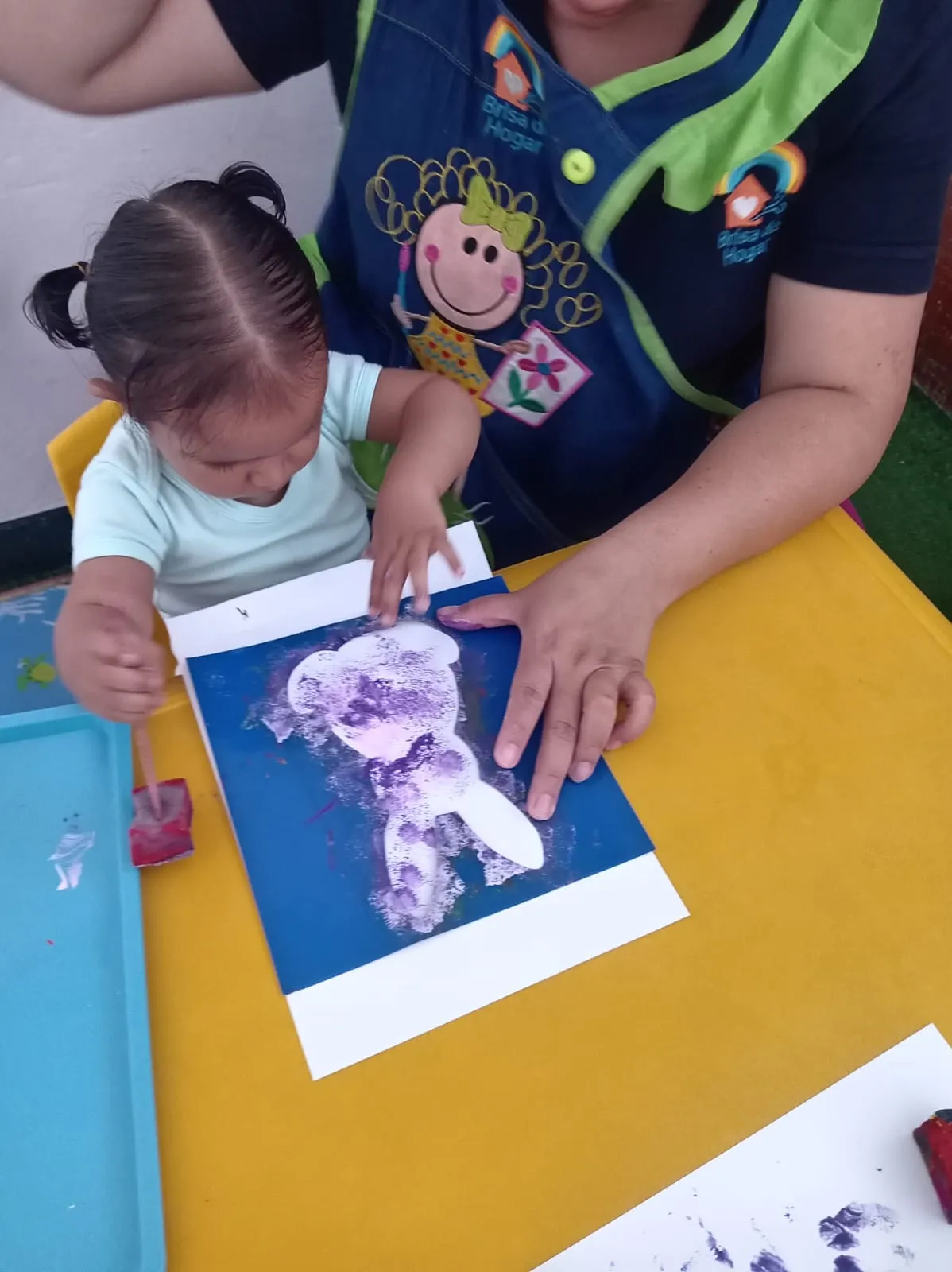 Educadora Brisa de Hogar guiando a niña — dedicación y amor en guardería Los Olivos