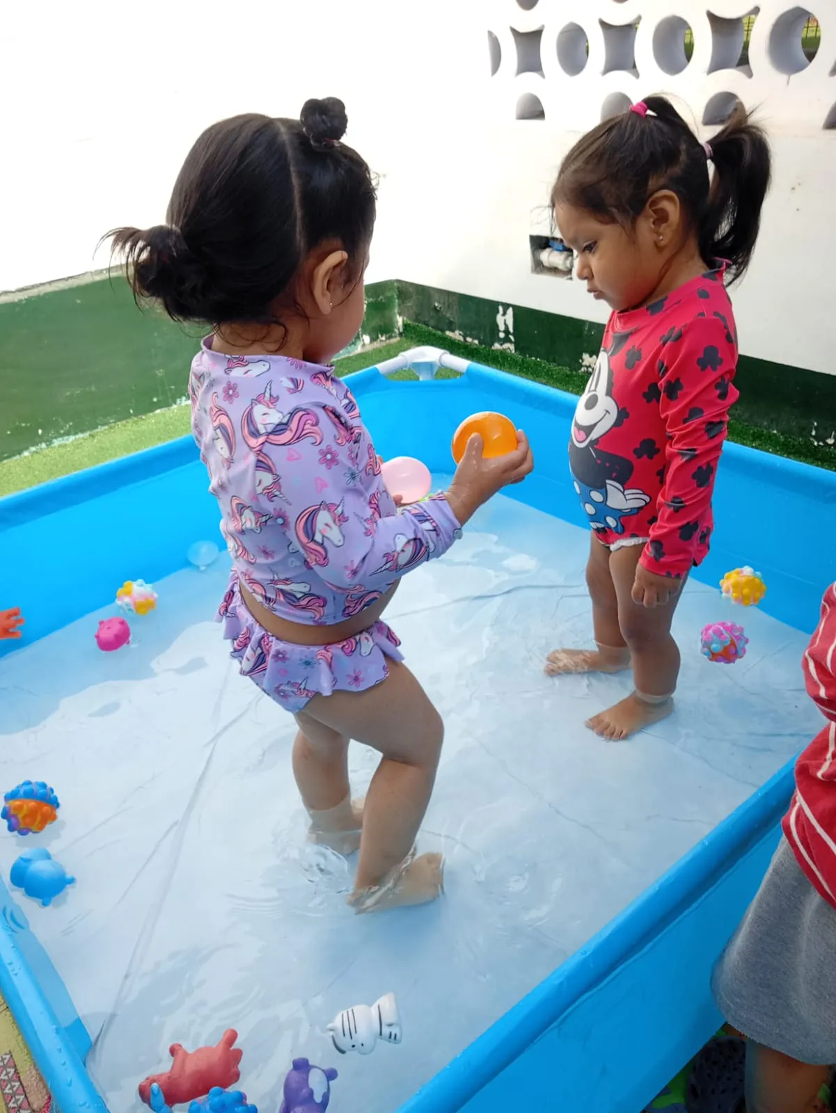 Niñas jugando con agua y juguetes — actividad lúdica en guardería Brisa de Hogar