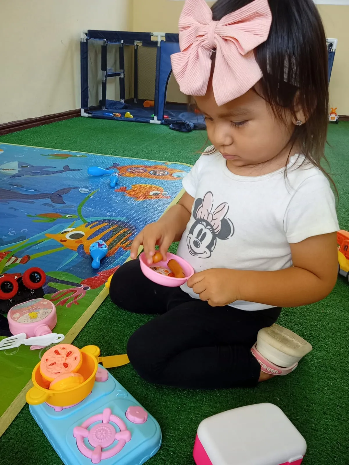 Niña en juego simbólico de cocina — desarrollo cognitivo en guardería Los Olivos